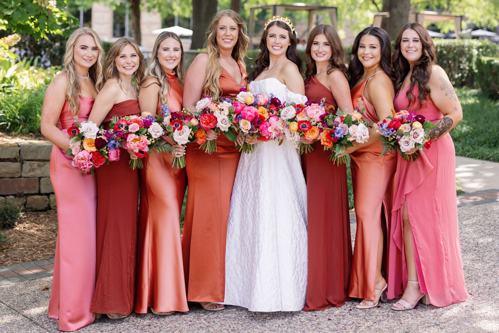 Shades of pink and orange bridesmaids attire for a fall wedding