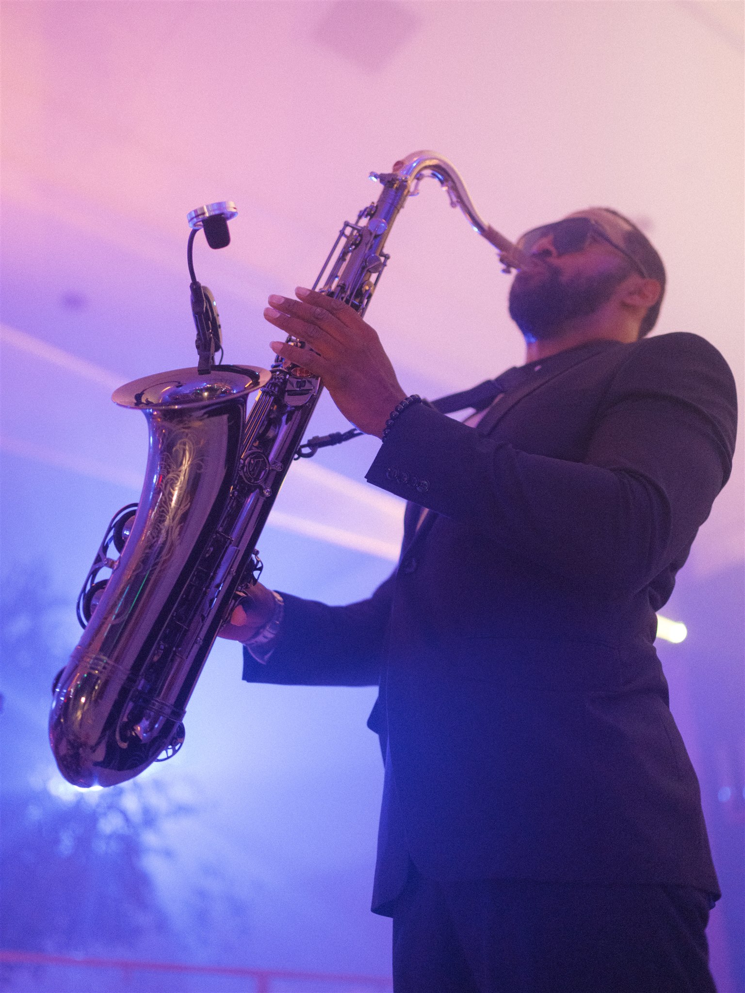 A saxophonist provides interactive entertainment at a wedding reception.