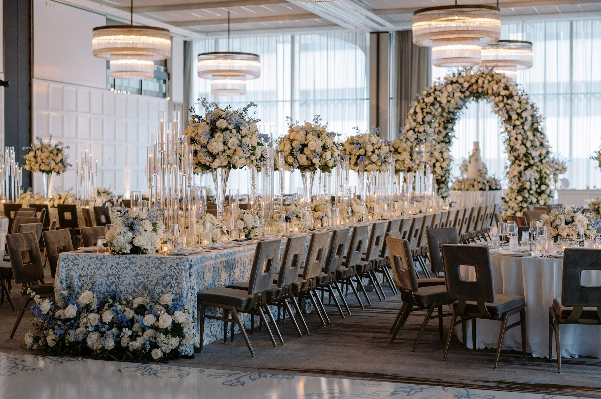 A classic, airy wedding reception design of pale blues and whites, with lush florals serving as the focal point.