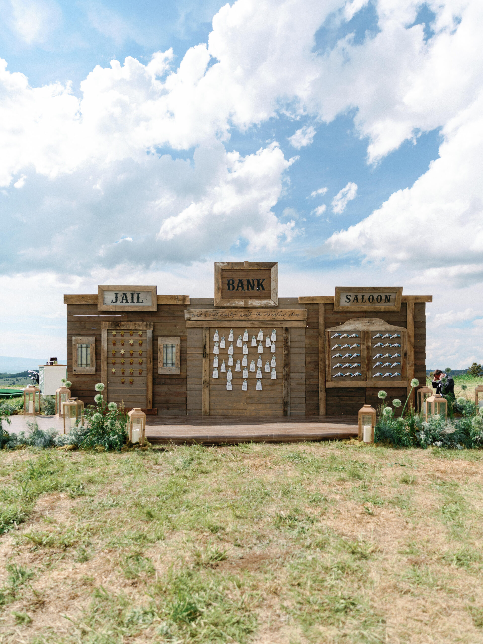 An Old West-themed escort wall at a ranch wedding featuring unique items that serve as escort cards.